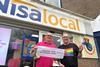 Kash Retails Kevin Polley presents a cheque outside Nisa Local