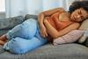 GettyImages_Woman on sofa with tummy ache_Credit LaylaBird