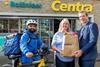 Delivery driver stands outside store with Centra store owner and company md