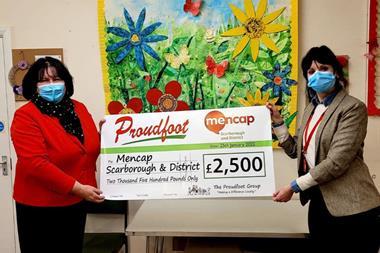 Proudfoot gives giant chequen to Mencap with funds raised through carrier bag sales
