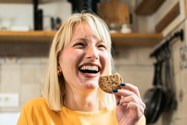 Joyful woman eating biscuit