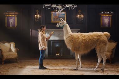 A woman trying to feed a Llama a banana in an ornate living room