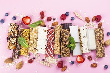 A selection of cereal and protein bars surrounded by fruit.