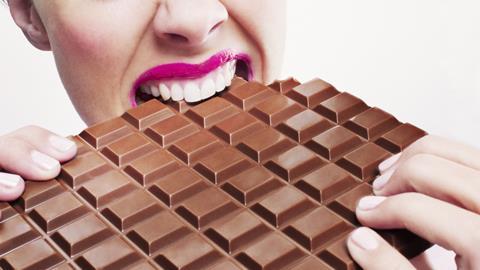 Pink lips biting huge chocolate bar