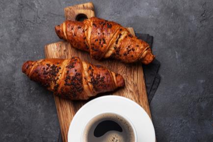 Morning goods croissants topped with chocolate and served with coffee