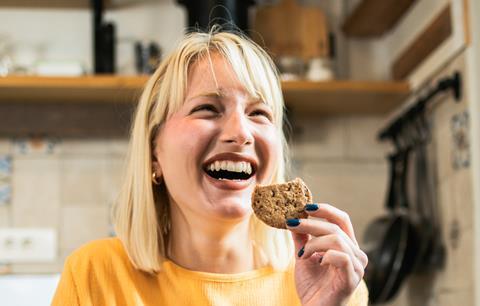 Joyful woman eating biscuit