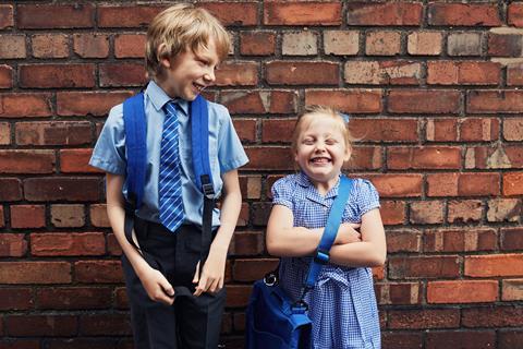 A smiling boy and girl in school uniform