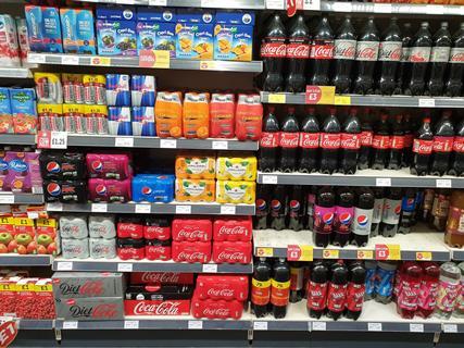 Multipack soft drinks cans on shelf in store