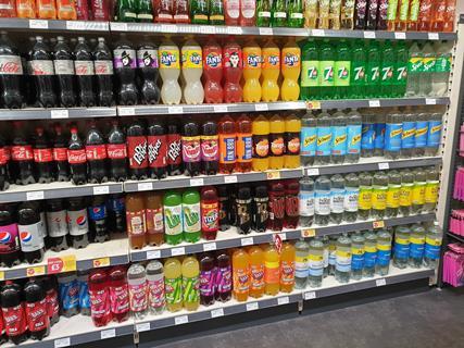 Large bottles of soft drinks on shelf in store