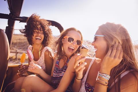 Teenagers eating ice cream on road trip