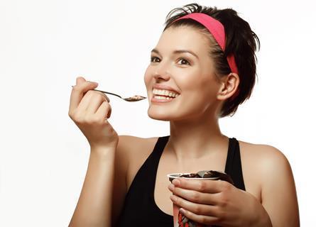 Woman in gym attire eating ice cream