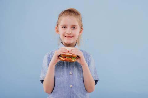 Happy girl about to eat a sandwich