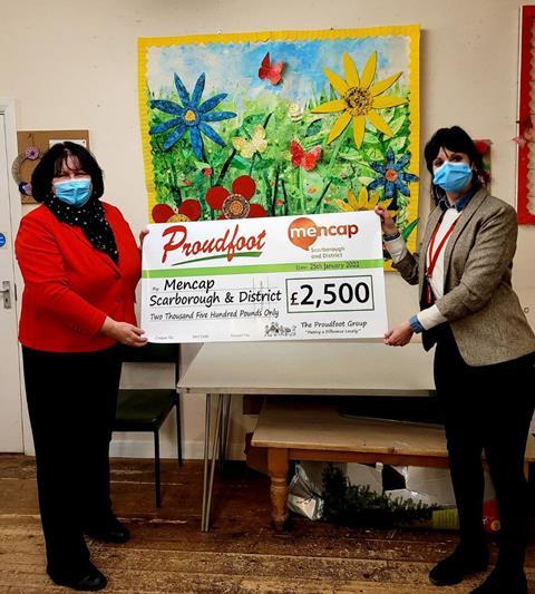 Proudfoot gives giant chequen to Mencap with funds raised through carrier bag sales
