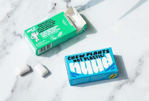 Open packs of blue peppermint and green Spearmint Nuud chewing gum on a white marbled surface