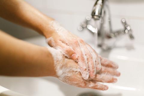 Soapy hands under tap