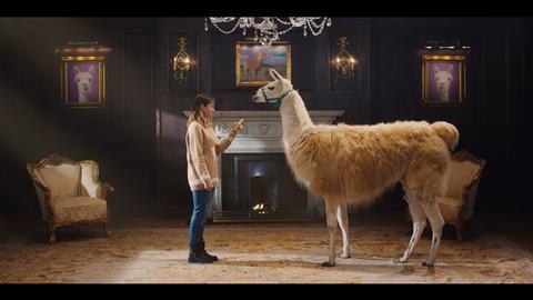 A woman trying to feed a Llama a banana in an ornate living room