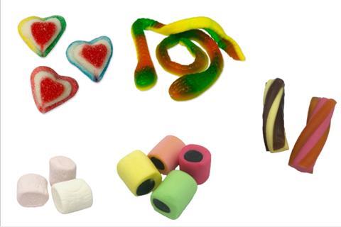 Selection of sweets including pink gummy hearts and snakes, marshmallows and liquorice