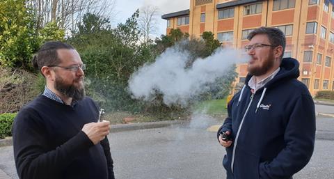 Two men vaping outside