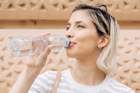 Shot of a woman drinking from a bottle of water