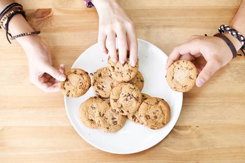 Hands reaching for cookies on plate