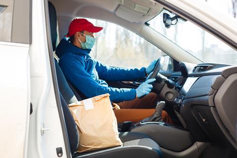 Man in car making home delivery in paper bag