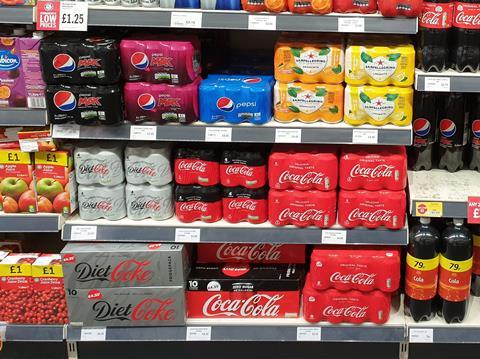 Multipack soft drinks cans on shelf in store