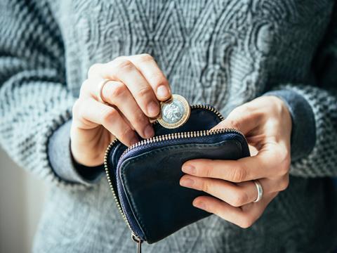 Woman putting coins into a purse_living wage_money