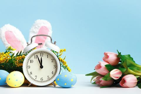 Easter scene with bunny ears, eggs, flowers and clock