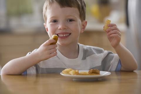 Smiling boy eating chicken nuggets and chips