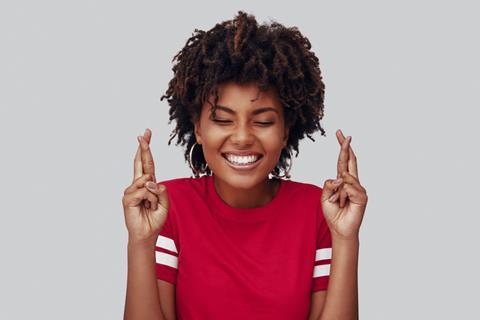 A lady feeling cautiously optimistic and crossing her fingers