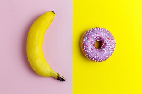 Yellow banana on pink background next to pink donut on yellow background